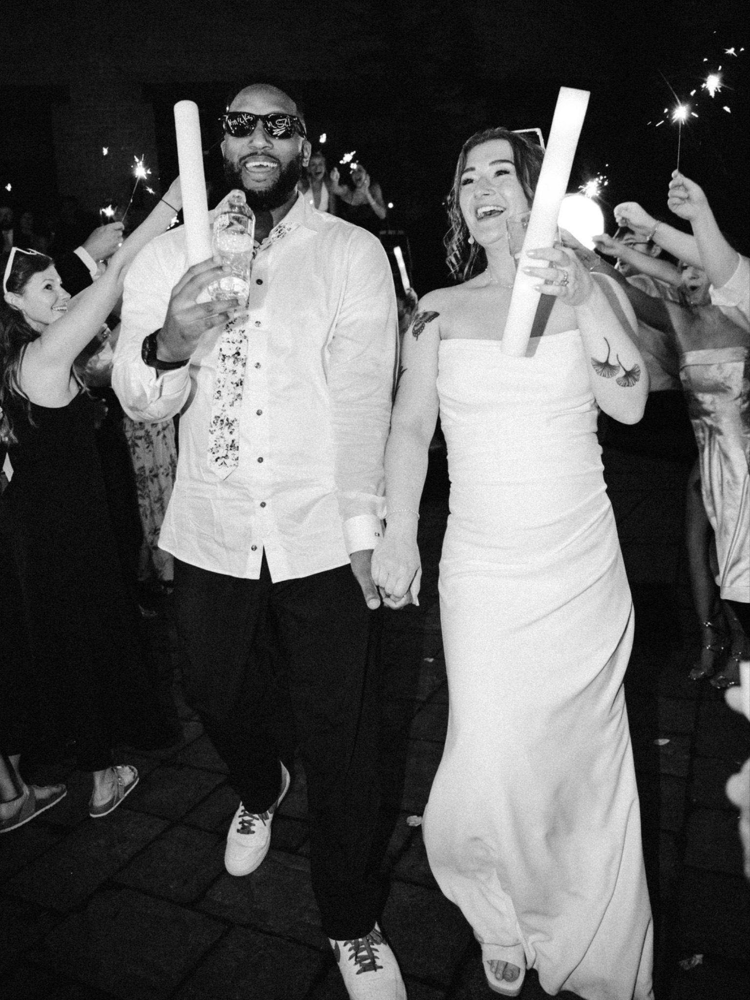 Gabrielle and Chandler laughing during their sparkler send-off at the end of the night