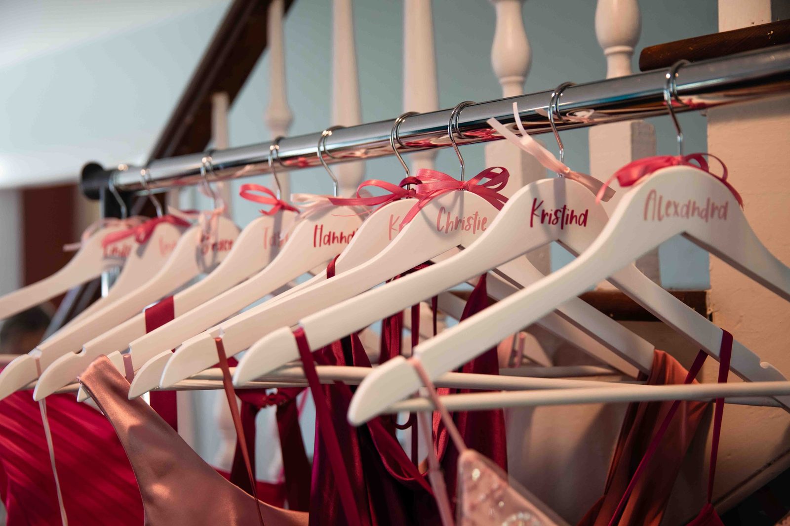 Personalized bridesmaid hangers with each name written in pink script